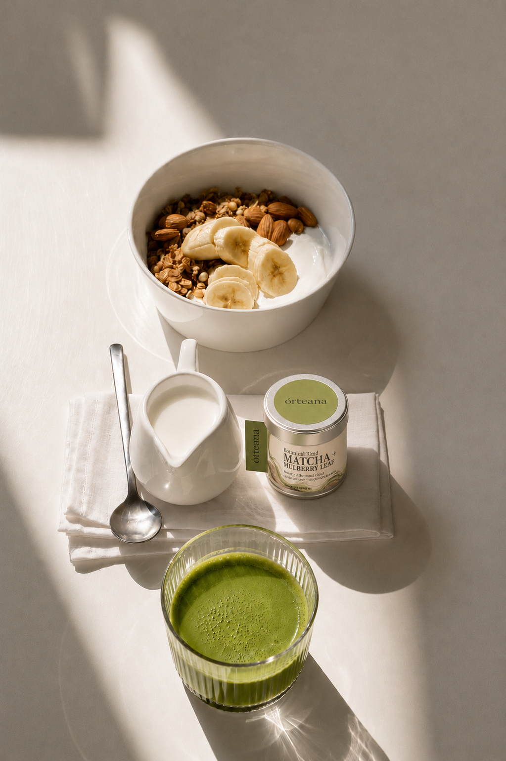 Vivid green Matcha + Mulberry Leaf blend pouring from a glass bowl into a white cup.